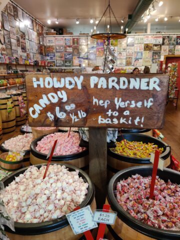 The sign inside the Yippy I-O Candy Co. says, "Hep yerself to a baskit"